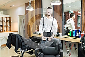 Hairdresser Smiling By Chair In Shop