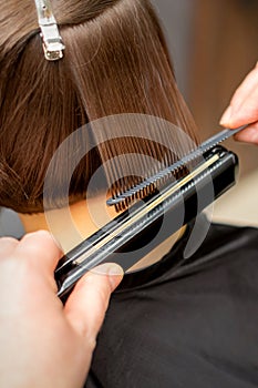 Hairdresser straightening the short hair