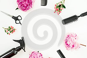 Hairdresser styler frame concept with spray, scissors, combs and peonies flowers on white background. Flat lay, top view