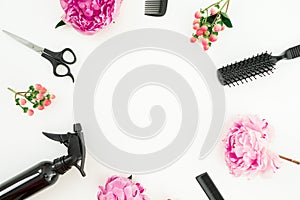 Hairdresser styler frame with spray, scissors, combs and peonies flowers on white background. Flat lay, top view