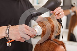 Hairdresser styling hair of a female client