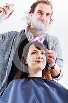 Hairdresser styling woman hair in shop