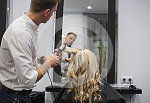 Hairdresser styling woman's hair