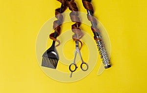 Hairdresser stylist tools, scissors, comb, brush, on a yellow background, horizontal