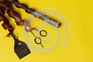 Hairdresser stylist tools, scissors, comb, brush, on a yellow background, horizontal