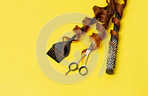 Hairdresser stylist tools, scissors, comb, brush, on a yellow background, horizontal