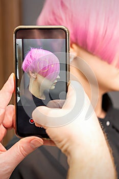 Hairdresser takes pictures of hairstyle