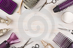 Hairdresser tools on wooden background with copy space in center