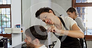 Hairdresser trimming her client hair