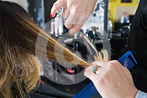 Hairdresser trimming ombre hair with scissors