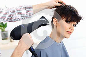 Hairdresser Using Dryer on Woman Wet Hair in Salon. Short Hair.