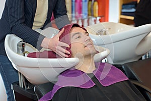 Hairdresser using towel to dry man`s hair