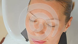 Hairdresser washes hair of client in beauty clinic