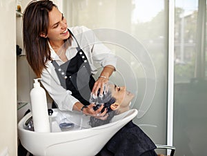 Hairdresser washes woman`s hair, top view