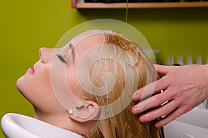 Hairdresser washing blond hair