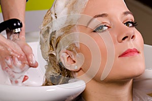 Hairdresser washing blond hair