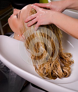 Hairdresser washing blond hair