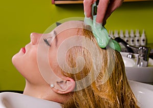 Hairdresser washing blond hair