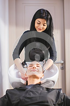 Hairdresser washing hair to a client