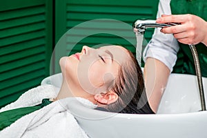 Hairdresser washing hair of woman