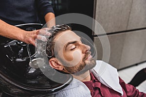 Hairdresser washing head of client