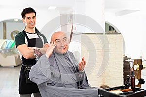 Hairdresser during washing head of positive man after shaving