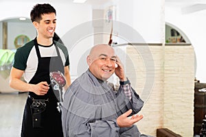 Hairdresser during washing head of positive man after shaving