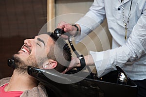 Hairdresser Washing Man Head In Barber Shop