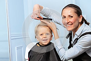 Hairdresser woman discuss how to cut forelock of the little boy photo