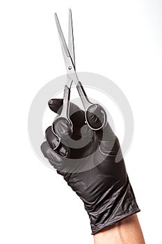 Hairdressers hand in black rubber glove holds a scissors