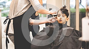 Hairdressers hands making hairstyle to child little boy in the barber shop hair cut professional - Little boy in the barber shop