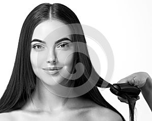 Hairdressing process. Girl model Hair Straightening Irons.Beautiful Woman with Long Straight Hair. Healthy Hair.