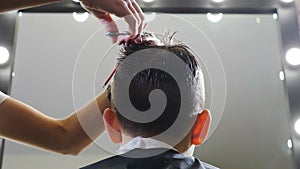 Hairdressing saloon. Children haircut in salon. Little boy hairdressing. hairdresser cuts hair with scissors. Child hair