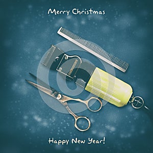 Hairdressing scissors, comb, and clipper on a dark background. Happy New Year and Merry Christmas. Greeting card for