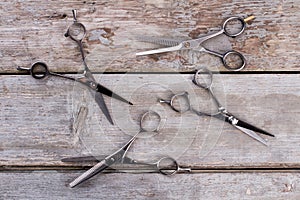 Hairdressing scissors on rustic wooden background.