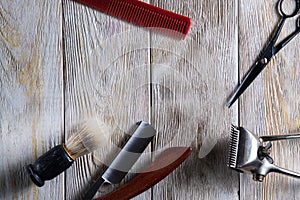 Hairdressing scissors vintage manual clipper comb brush dangerous razor are on a white weathered wooden surface