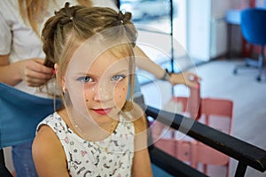 Hairdressing services. Reating hairstyle. Hair styling process. Children hairdressing salon