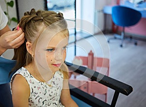 Hairdressing services. Reating hairstyle. Hair styling process. Children hairdressing salon