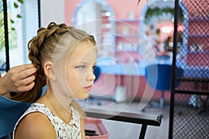 Hairdressing services. Reating hairstyle. Hair styling process. Children hairdressing salon