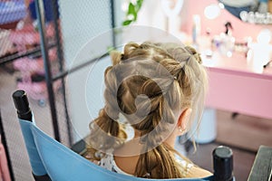 Hairdressing services. Reating hairstyle. Hair styling process. Children hairdressing salon