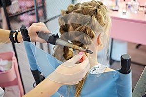 Hairdressing services. Reating hairstyle. Hair styling process. Children hairdressing salon