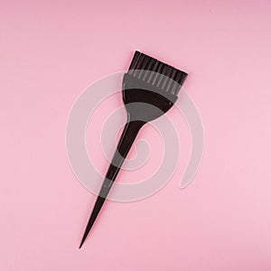 Hairdressing tools with copy space, hair coloring brush on pastel colored paper background, top view and flat lay photo