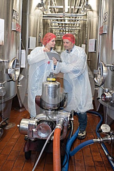 Hairnet worker dealing with barrels in interior winemaker factory