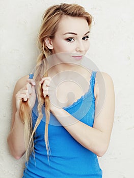 Hairstyle. Blond woman teenage girl plaiting braid hair.