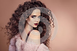 Hairstyle. Fashion brunette girl with Long curly hair, beauty ma