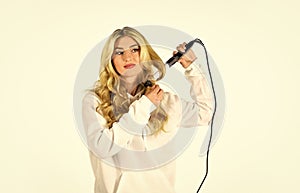 Hairstyle And Hairdressing. girl curling long hair with curler. Girl care about her hairstyle. woman curling hair with