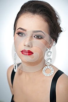 Hairstyle and make up - beautiful female art portrait with earrings. Elegance. Genuine natural brunette with jewelry