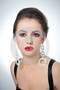 Hairstyle and make up - beautiful female art portrait with earrings. Elegance. Genuine natural brunette with jewelry