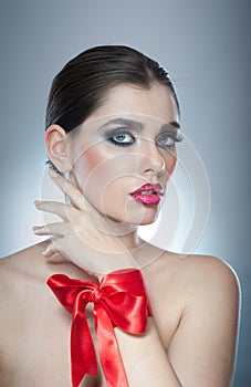 Hairstyle and Make up - beautiful female art portrait with red ribbon. Elegance. Genuine Natural brunette with ribbon - studio