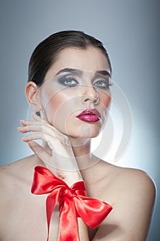 Hairstyle and Make up - beautiful female art portrait with red ribbon. Elegance. Genuine Natural brunette with ribbon - studio